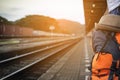 Man backpack waiting train at train station in Thailand.