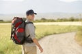 Man With Backpack Walking On Country Road