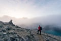 man with backpack walking on winding road against foggy landscape. nepal Royalty Free Stock Photo