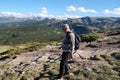 a man with a backpack walks along a mountain path