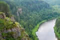 Man backpacker practicing yoga warrior pose on edge of the mountain cliff, Panoramic view to the river Royalty Free Stock Photo