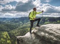 man backpacker running up on mountain top cliff edge