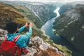 Man backpacker taking photo by smartphone relaxing on mountain cliff Royalty Free Stock Photo