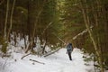 Man is backpacking in winter forest