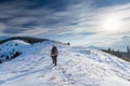 Man is backpacking in winter mountains