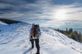 Man is backpacking in winter mountains