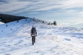 Man is backpacking in winter mountains