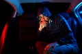 Man in the backseat of a car wearing a hoodie shirt