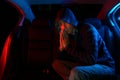 Man in the backseat of a car wearing a hoodie shirt