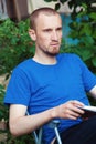 Man at backyard drinking coffee and reading book Royalty Free Stock Photo