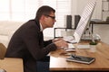 Man with bad posture working on computer in office Royalty Free Stock Photo