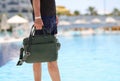 Man with bag for documents walking along edge of swimming pool closeup Royalty Free Stock Photo