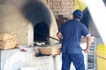 Man baking bread ina a rustic traditional oven Royalty Free Stock Photo