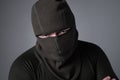 A man in a balaclava, as a concept of special forces or extremist clothes, stands with a menacing look