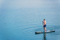man balancing on supboard paddling