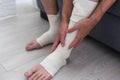 Man bandaging injured ankle. Injury leg. First aid for sprained ligament or tendon Royalty Free Stock Photo