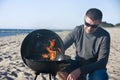 Man and barbecue on beach Royalty Free Stock Photo
