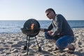 Man and barbecue on beach