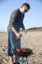 Man and barbecue on beach Royalty Free Stock Photo