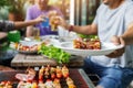 A man with a barbecue plate at a party between friends. Food, people and family time concept