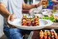 A man with a barbecue plate at a party between friends. Food, people and family time concept Royalty Free Stock Photo