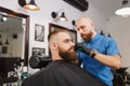 The man barber serves the client in the salon