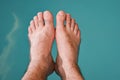 Man with bare feet relaxing at the indoor pool Royalty Free Stock Photo
