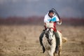 Man is bareback riding an adorned horse before an Epiphany celebration horse race