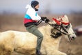 Man is bareback riding an adorned horse before an Epiphany celebration horse race