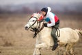 Man is bareback riding an adorned horse before an Epiphany celebration horse race