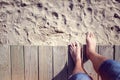 Man barefoot stepping off boardwalk onto the beach sand Royalty Free Stock Photo