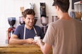 Man, barista and cup in coffee shop, serving customer and working in restaurant or small business. Male person Royalty Free Stock Photo