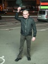 A man with a baseball cap in his hands at night on the street Royalty Free Stock Photo