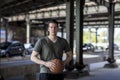 Man With a Basketball Standing Under a City Bridge Royalty Free Stock Photo