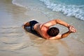 Man in bathingsuit lying at the beach Royalty Free Stock Photo