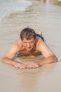 man in bathingsuit is lying at the beach and enjoying the saltwater Royalty Free Stock Photo