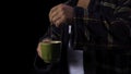 Man in a Bathrobe with a Cup of tea. Stock. A man makes tea on a black background. Bad mood concept Royalty Free Stock Photo