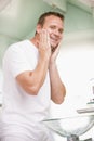 Man in bathroom applying aftershave