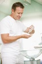 Man in bathroom applying aftershave