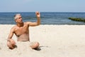 Man on the beach holding stone