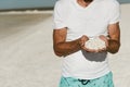 Man tourist holding tiny white sea shells in both hands Royalty Free Stock Photo