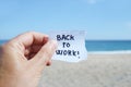 Man on the beach and text back to work in a note Royalty Free Stock Photo