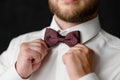 A man with a beard adjusts his stylish bow tie, close-up. The concept of the wedding day, fashion, business,men& x27;s Royalty Free Stock Photo