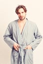 Man with beard in blue dressing gown on grey background. Royalty Free Stock Photo