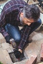 Man with beard breaks masonry hammer and chisel