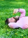 Man with beard on calm face sniffs dandelion. Peace and tranquility concept. Bearded man with daisy flowers in beard lay