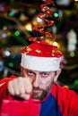 Man with beard in Christmas hat on background of tree Royalty Free Stock Photo