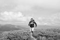 Man with beard enjoy freedom, runs on top of mountain. Hipster feels free while hiking, sky background. Hipster or Royalty Free Stock Photo