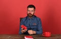 Man with beard and glasses holds alarm clock, red background Royalty Free Stock Photo