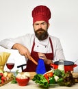 Man with beard grates carrot on grater on white background. Royalty Free Stock Photo